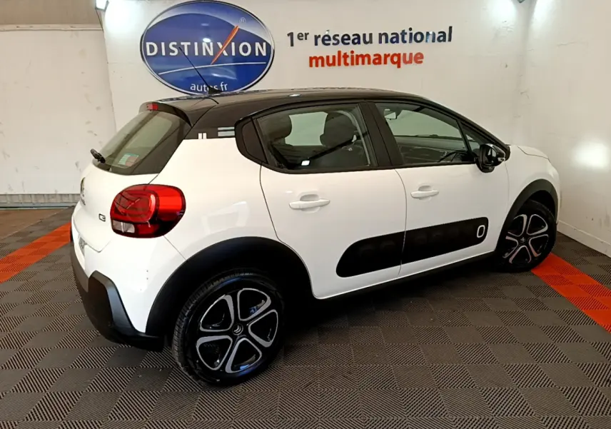 Vue 3/4 arrière droite d'une Citroën C3 blanche 2019 avec toit noir et protections latérales noires.