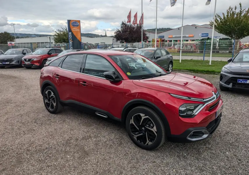 Citroën C4 2024 rouge foncé vue 3/4 avant droit avec jantes alliage et rétroviseurs noirs brillants.