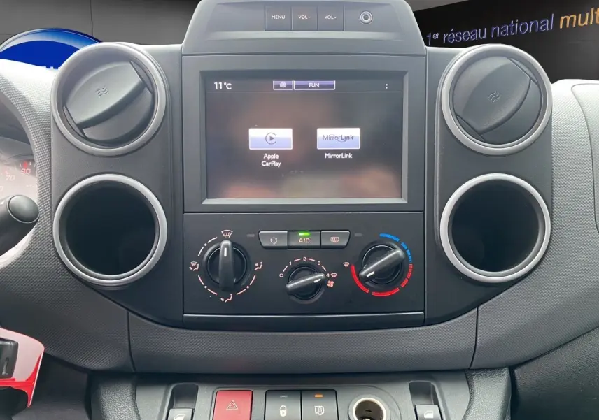 Vue rapprochée du tableau de bord du Citroën Berlingo blanc 2018, avec écran tactile et commandes de climatisation.