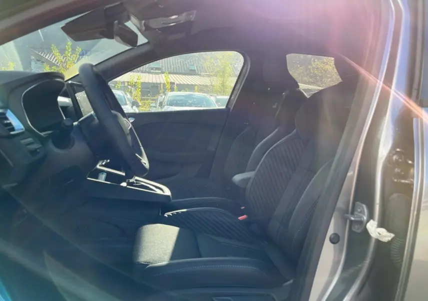 Vue intérieure côté gauche de la Renault Clio V E-Tech 145 Esprit Alpine Bose 2025 avec sièges sport noirs et volant cuir.