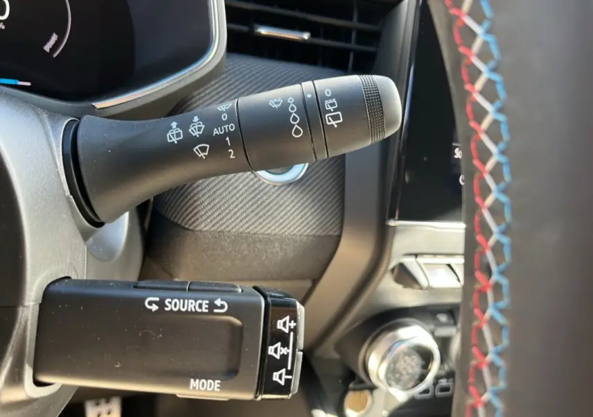 Détail intérieur du volant de la Renault Clio V E-Tech 145 Esprit Alpine Bose 2025, avec surpiqûres tricolores visibles.