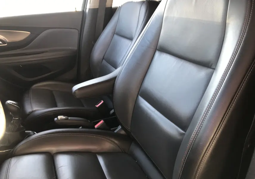 Gros plan sur les sièges avant en cuir noir de l'Opel Mokka blanc, version 1.6l cdti 136ch cosmo pack, intérieur soigné.