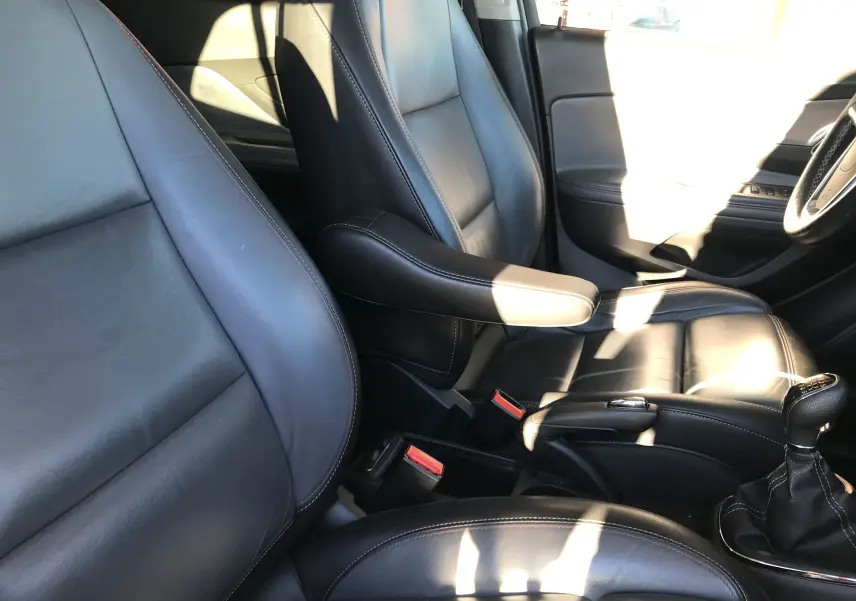 Vue rapprochée des sièges avant en cuir noir de l'Opel Mokka 2015, avec levier de vitesse manuel visible côté droit.