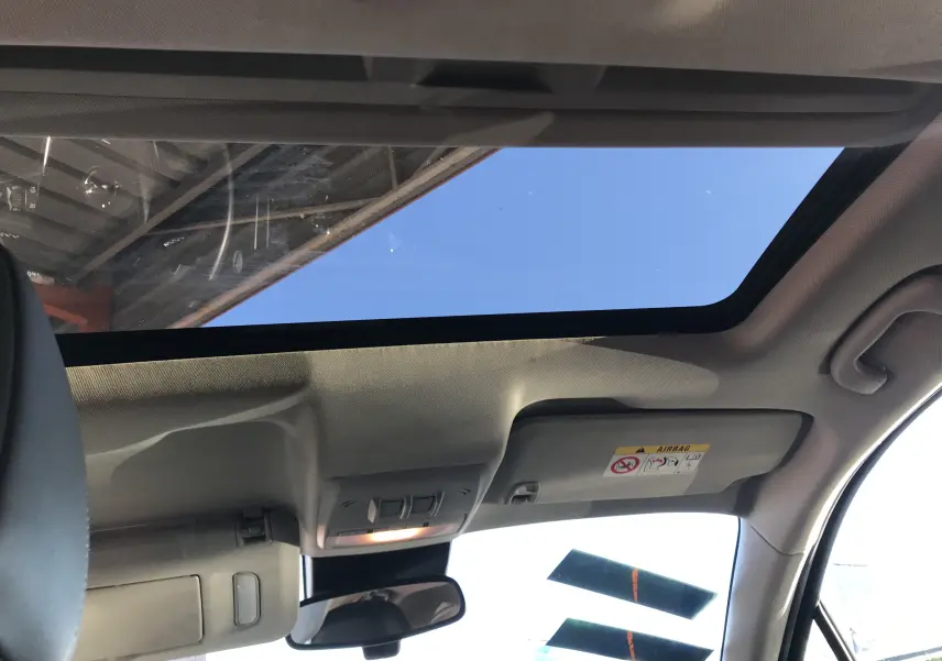 Vue intérieure du toit ouvrant panoramique de l'Opel Mokka blanc, avec pare-soleil et rétroviseur central visibles.