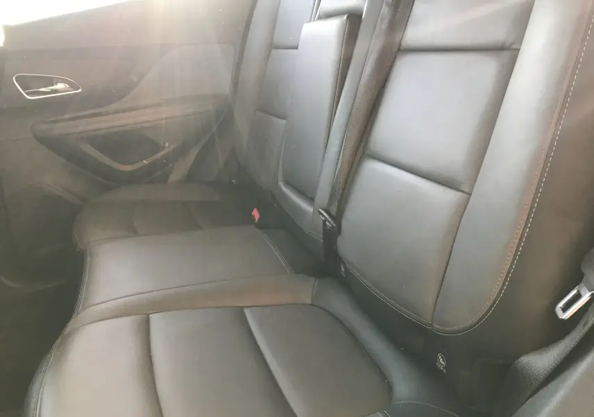 Vue intérieure des sièges arrière en cuir noir de l'Opel Mokka 2015, avec ceinture de sécurité et porte côté gauche visible.