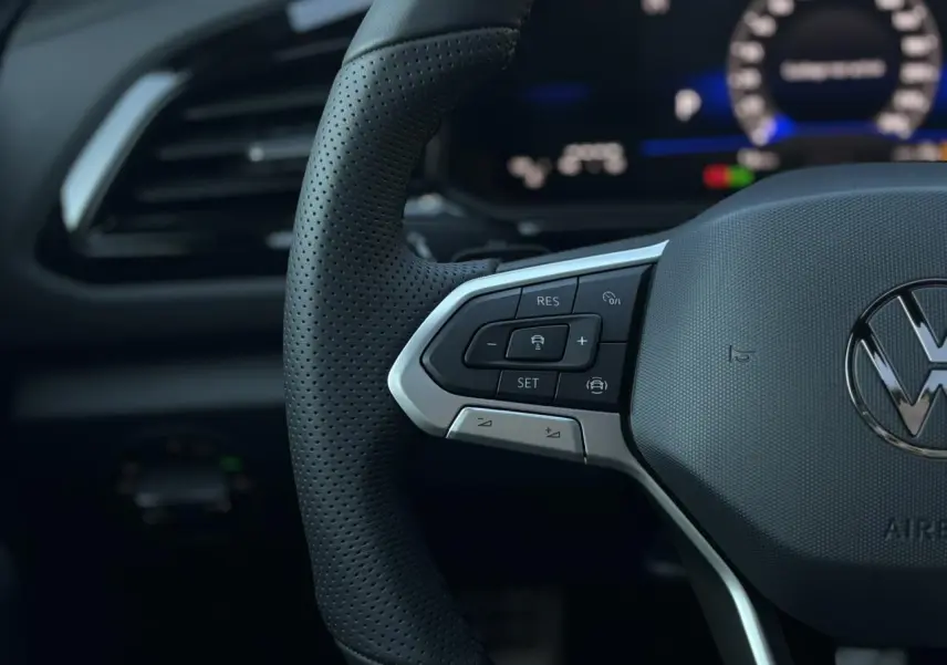 Gros plan sur le volant multifonction en cuir noir avec logo Volkswagen du Volkswagen T-Roc 2.0 TDI R-Line 2025.
