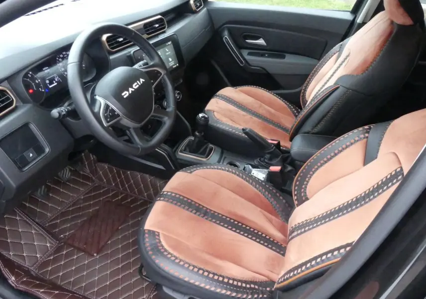 Intérieur du Dacia Duster 2023 version Extreme, vue côté conducteur, sièges marron et noir avec volant marqué DACIA.