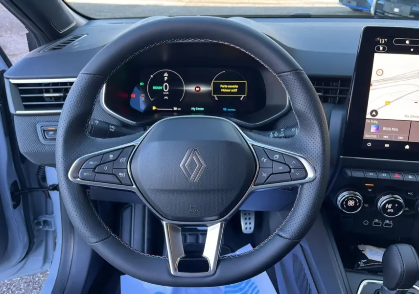 Vue intérieure centrée sur le volant cuir multifonctions de la Renault Clio V E-Tech 145 Esprit Alpine gris schiste.