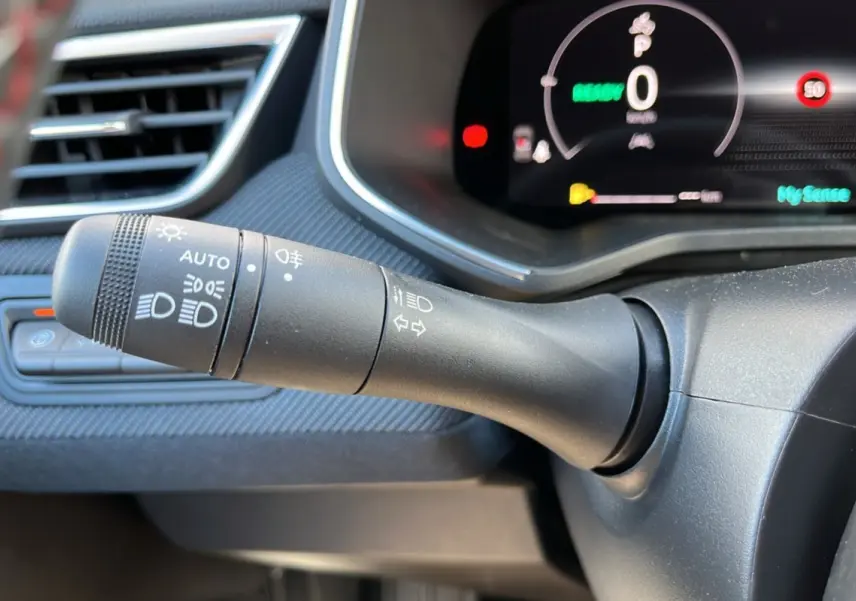 Gros plan sur la commande des feux et clignotants du tableau de bord d’une Renault Clio V E-Tech 145 Esprit Alpine.