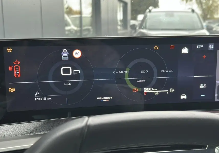 Tableau de bord numérique du Peugeot 3008 Hybrid 2024 affichant vitesse, autonomie et mode éco, vue frontale intérieure.
