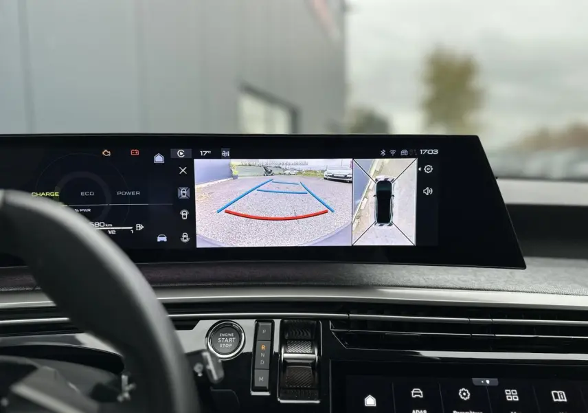 Vue intérieure du tableau de bord du Peugeot 3008 Hybrid 2024 avec écran affichant la caméra 360° en marche arrière.