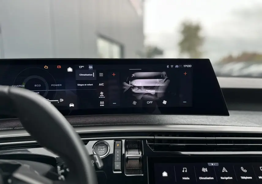 Vue intérieure du tableau de bord du Peugeot 3008 Hybrid 2024 avec écran tactile panoramique et commandes digitales.