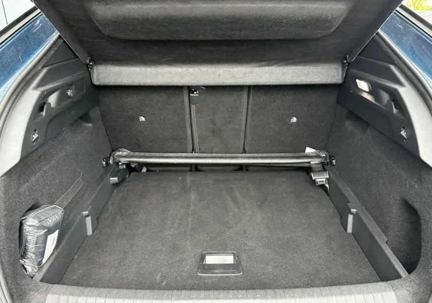 Coffre ouvert du Peugeot 3008 Hybrid 145 bleu Obsession, vue intérieure arrière montrant l'espace de chargement.