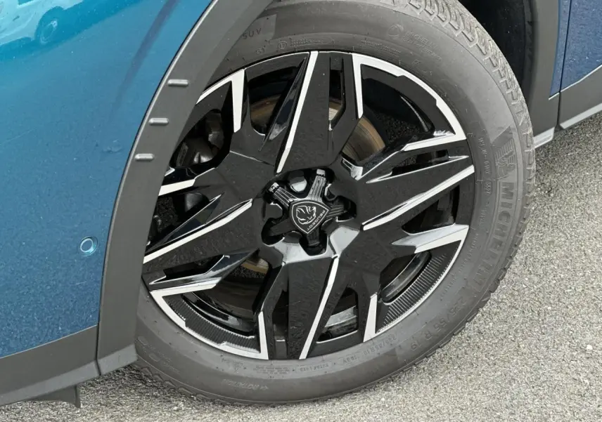 Gros plan sur la jante alliage noire et diamantée 19'' du côté avant gauche d'un Peugeot 3008 Bleu Obsession.