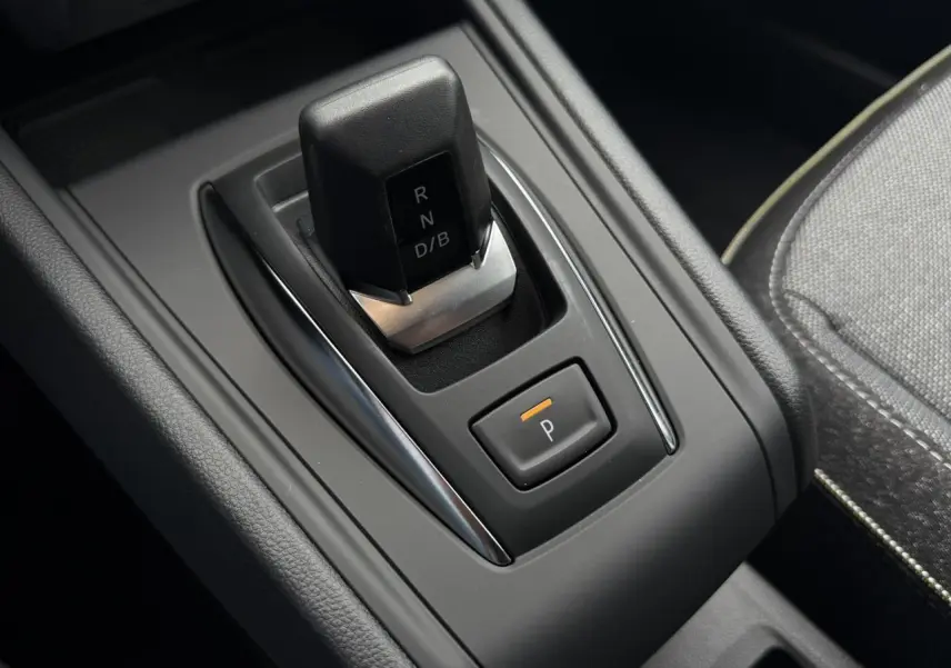 Gros plan sur la commande de boîte automatique noire du Renault Captur 2026, avec bouton de stationnement orange.