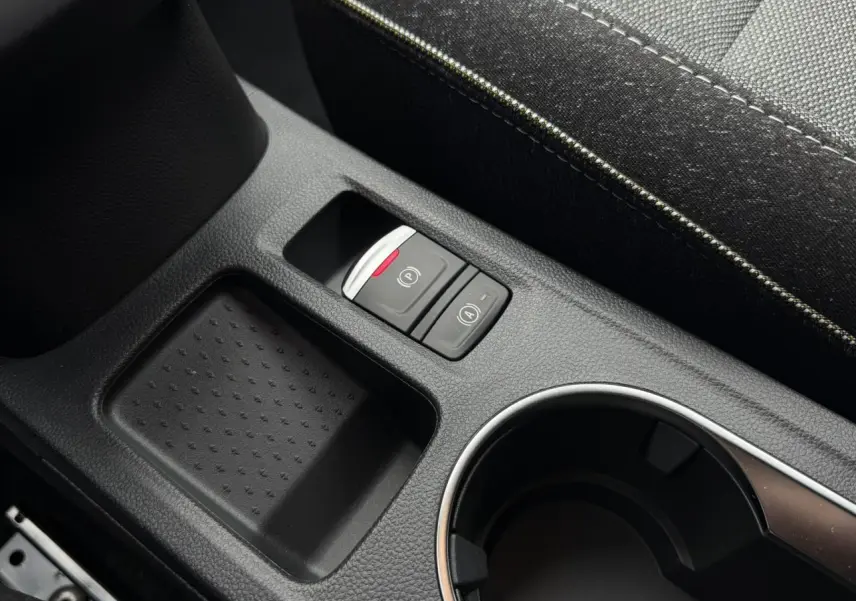 Gros plan sur la console centrale noire du Renault Captur 2026, avec boutons frein de parking électrique et auto hold.