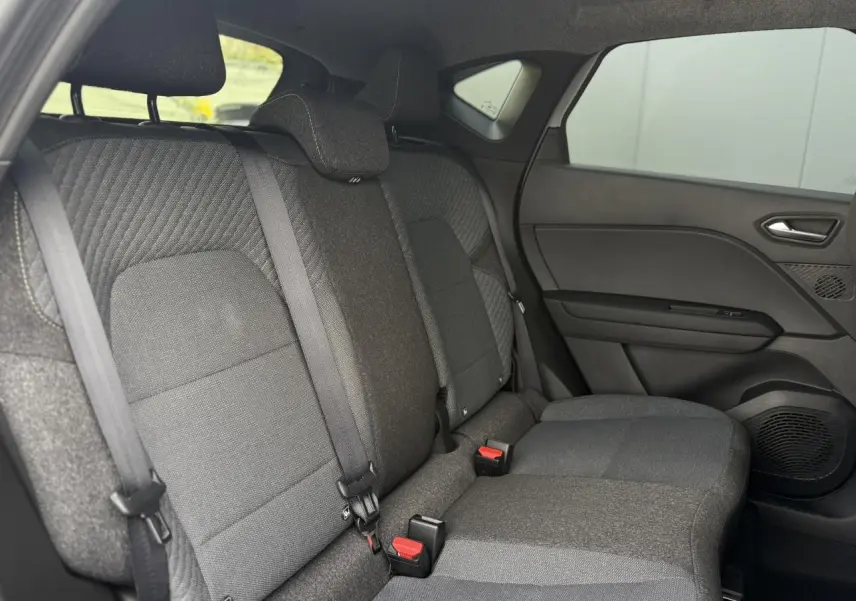 Vue intérieure côté droit des sièges arrière en tissu gris du Renault Captur 2026 version hybride avec ceinture de sécurité.