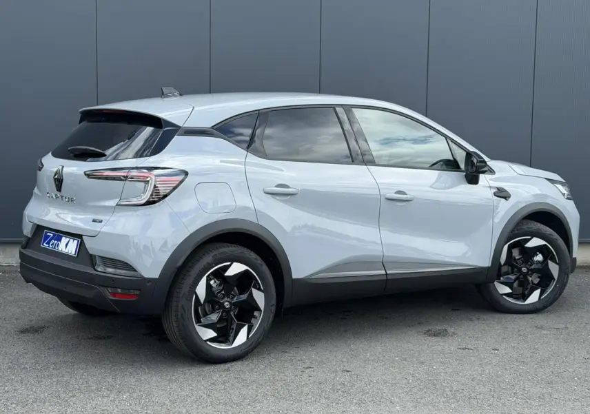 Vue de profil droit du Renault Captur gris Rafale 2026 avec jantes noires et détails noirs sur les rétroviseurs et bas de caisse.