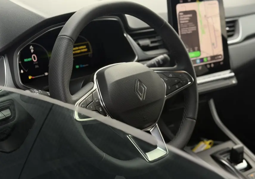 Vue rapprochée du volant noir en textile refined du Renault Captur 2026 avec tableau de bord numérique et écran tactile.