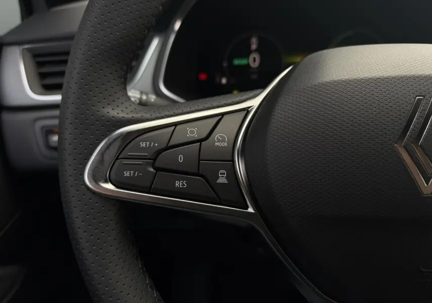 Gros plan sur le volant en textile perforé du Renault Captur gris Rafale, avec commandes intégrées côté gauche.