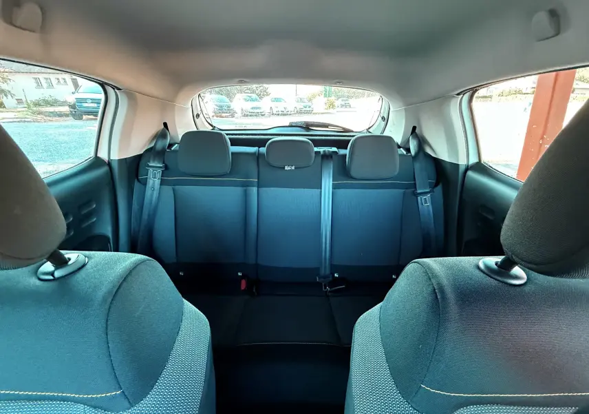 Vue intérieure arrière montrant les sièges arrière noirs d'une Citroën C3 blanche de 2021.