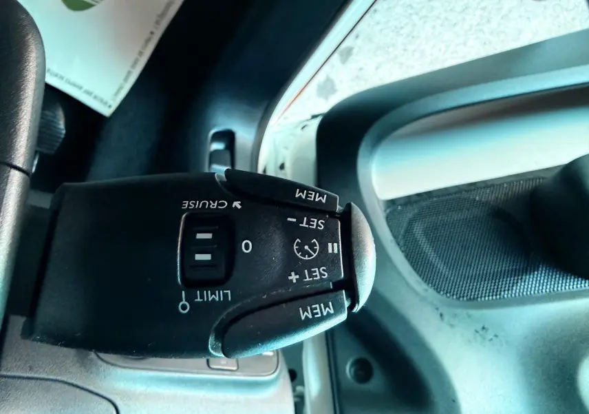 Gros plan sur la commande de régulateur de vitesse dans l'habitacle d'une Citroën C3 blanche de 2021.