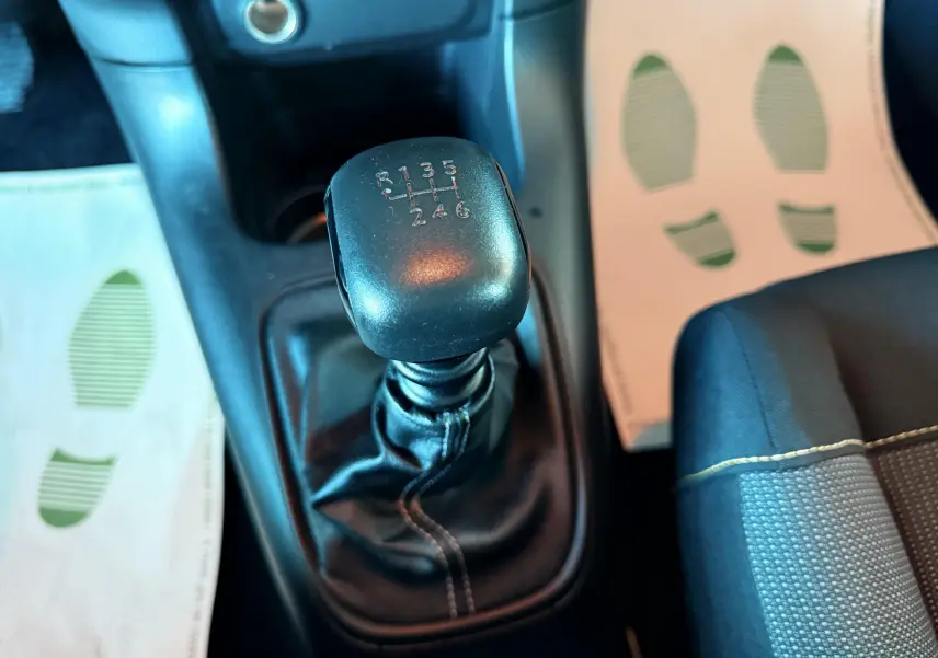 Le levier de vitesse manuel noir en gros plan dans l'habitacle d'une Citroën C3 blanche de 2021.