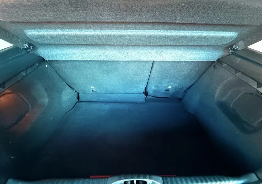 Coffre ouvert vu de l'arrière d'une Citroën C3 blanche, montrant un espace de chargement vide et propre.