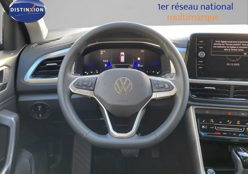 Vue intérieure centrée sur le volant du Volkswagen T-Roc 2025, tableau de bord digital et écran tactile visibles.
