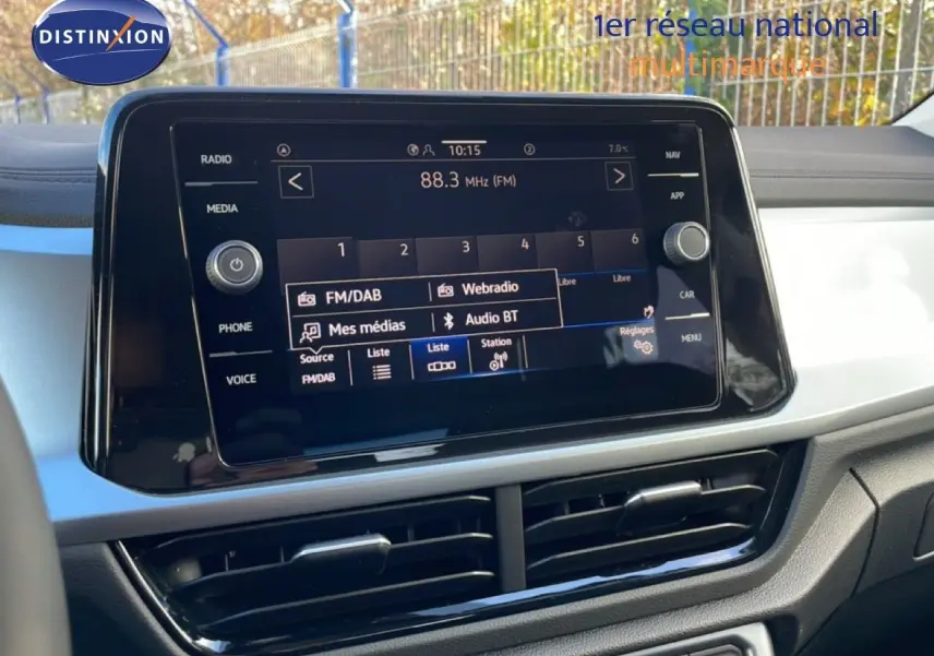 Écran tactile central du tableau de bord du Volkswagen T-Roc gris Pyrite, affichant les options radio et multimédia.