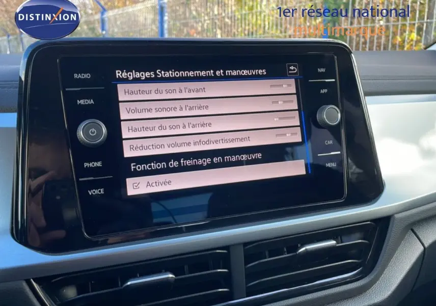 Vue rapprochée de l’écran tactile central du Volkswagen T-Roc gris pyrite, affichant les réglages de stationnement et manœuvres.