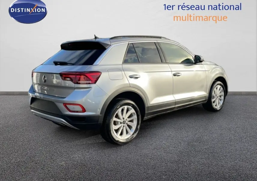 Volkswagen T-Roc gris pyrite métal en 3/4 arrière droit, avec jantes alliage et vitres teintées.