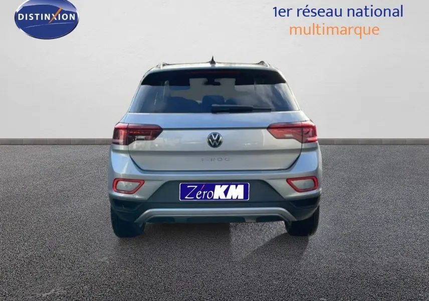 Vue arrière d'un Volkswagen T-Roc gris pyrite métal 2025 avec feux LED et plaque Zéro KM visible.