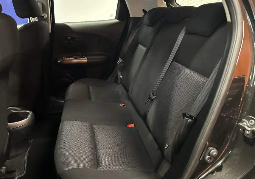 Vue intérieure côté droit des sièges arrière noirs en tissu du Nissan Juke dci 110 Acenta avec portières ouvertes.