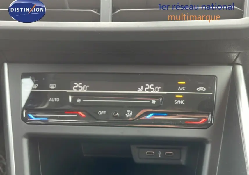 Panneau de commande de climatisation digitale de la Volkswagen Polo blanche, affichant 25°C en mode automatique.