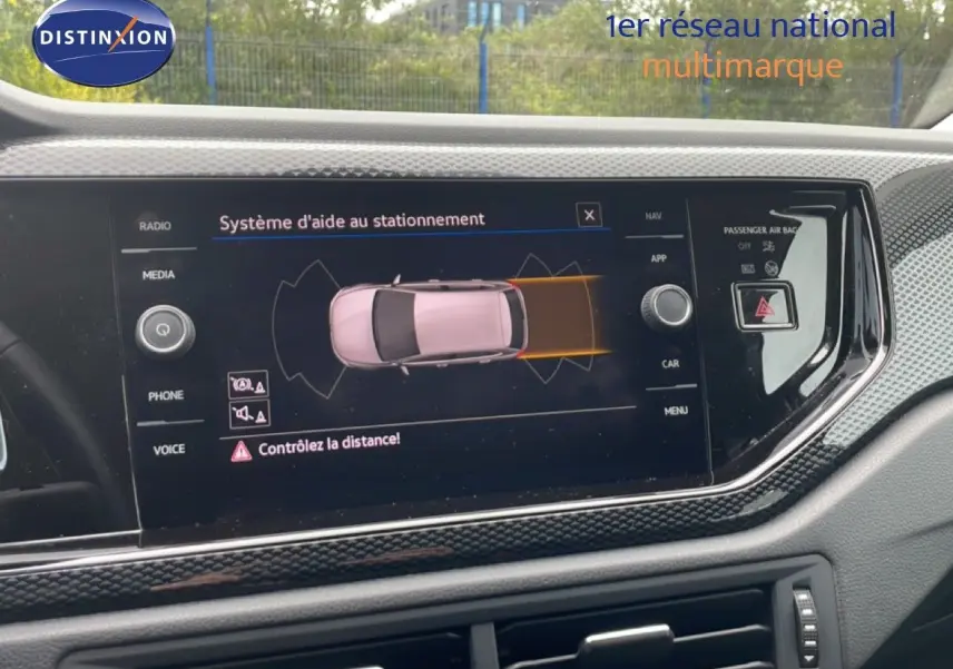 Écran central du tableau de bord d'une Volkswagen Polo blanche 2022 affichant le système d'aide au stationnement.