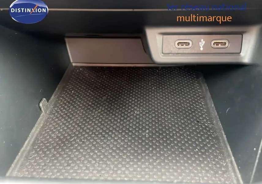 Gros plan sur la zone de rangement intérieure avec deux ports USB-C visibles dans une Volkswagen Polo blanche.