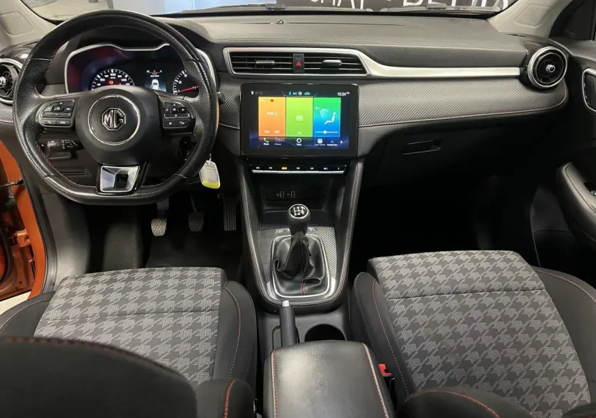 Vue intérieure avant du MG ZS 2022 avec volant cuir, écran tactile 10,1 pouces et sellerie tissu à motifs gris.