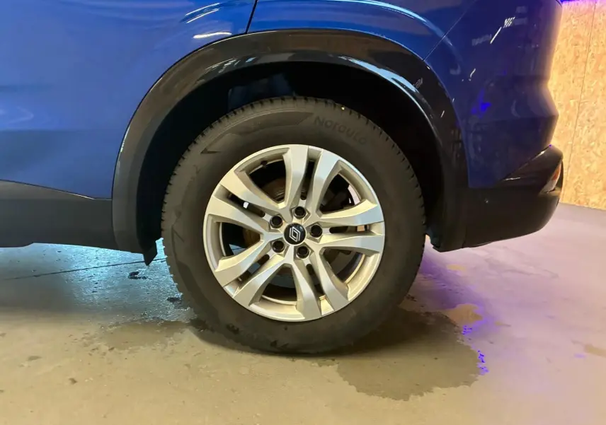 Gros plan sur la roue arrière droite d’un Renault Austral bleu 2024, soulignant la jante alliage et l’arche de roue noire.