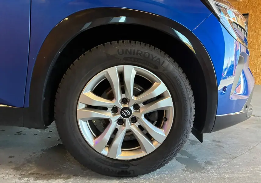Gros plan sur la roue avant droite du Renault Austral bleu 2024, mettant en valeur la jante argentée et le pneu Uniroyal.