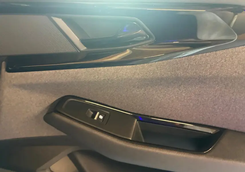 Détail de la porte intérieure côté droit du Renault Austral 2024, avec bouton de commande de vitre et finition tissu gris noir.