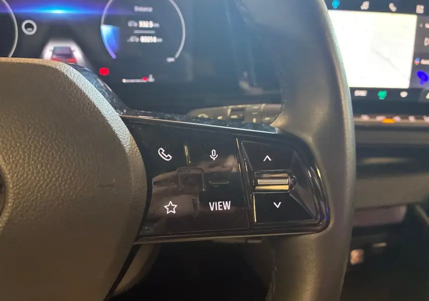 Gros plan sur les commandes à droite du volant du Renault Austral 2024, avec tableau de bord numérique en arrière-plan.
