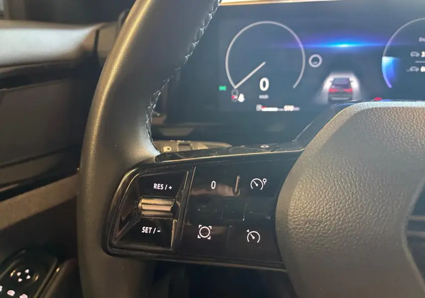 Gros plan sur la partie gauche du volant du Renault Austral 2024, avec commandes de régulateur et tableau de bord numérique.
