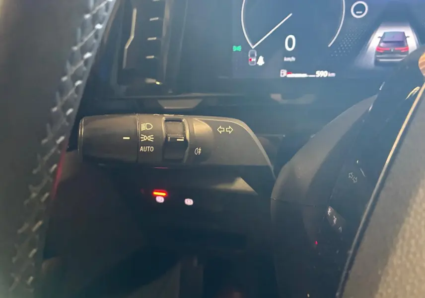 Gros plan sur la manette de clignotants et phares automatiques du tableau de bord du Renault Austral 2024, intérieur noir.