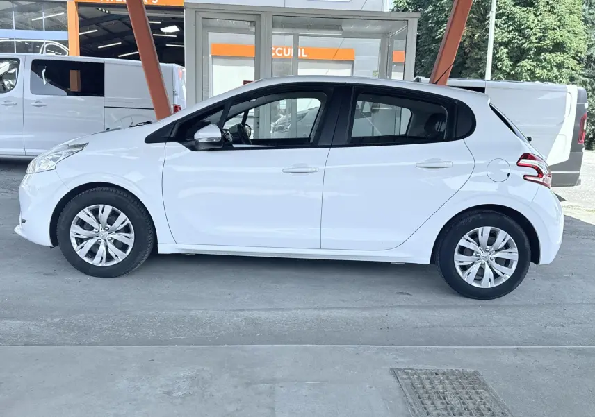 Peugeot 208 blanche vue de profil côté gauche, avec jantes alliage et portes arrière visibles, stationnée en extérieur.