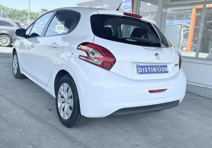 Peugeot 208 blanc vue 3/4 arrière droit, avec feux arrière distinctifs et logo lion sur hayon.