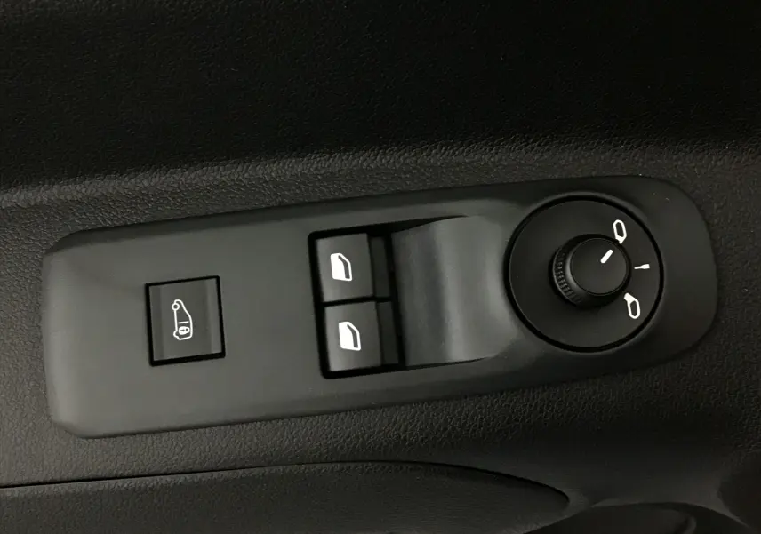 Gros plan sur les commandes électriques des vitres et des rétroviseurs côté conducteur d'un Peugeot Partner blanc.