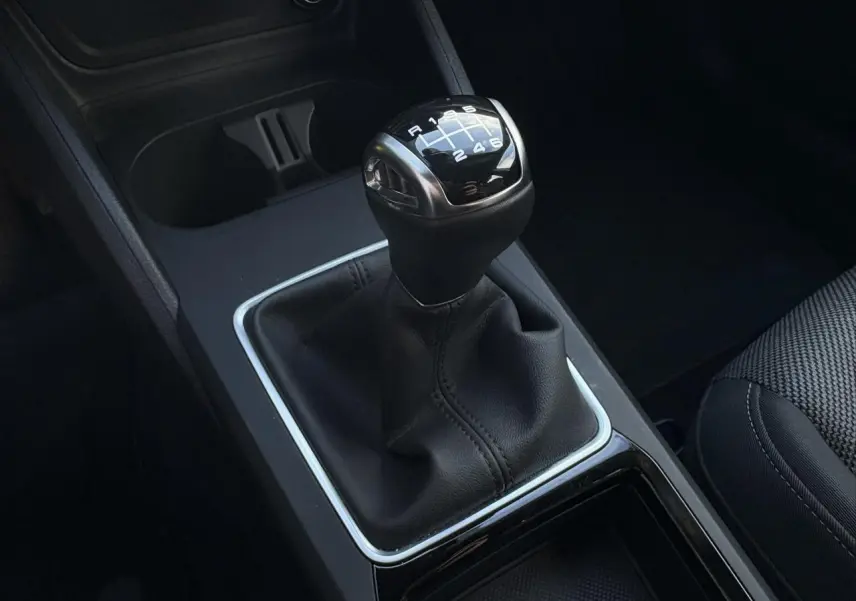 Gros plan sur le levier de vitesses manuel noir de l’Audi Q2 30 TDI 116 S-Line, intérieur sobre et moderne.