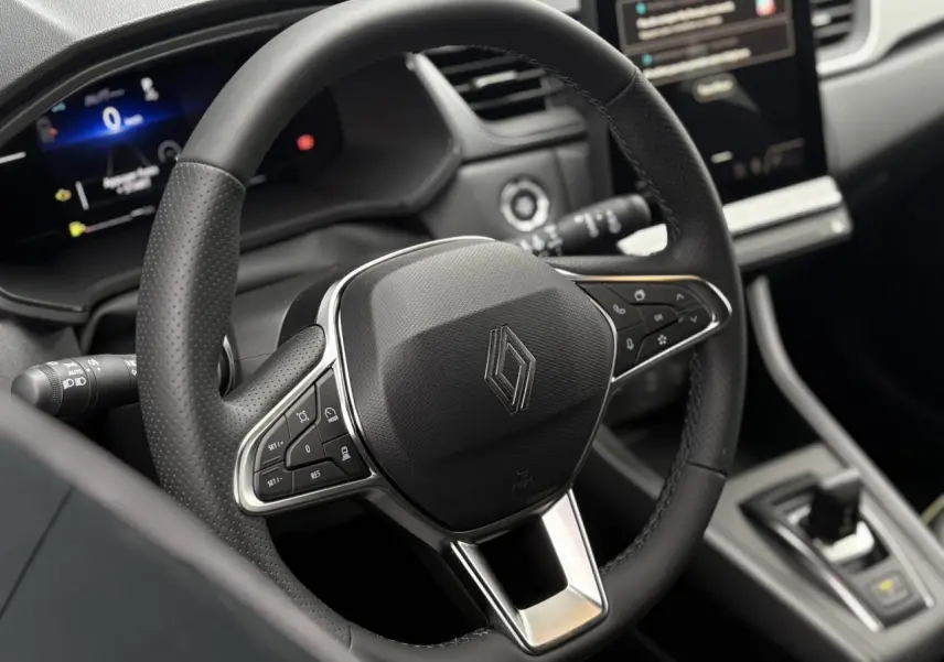 Vue rapprochée du volant noir perforé du Renault Captur 2026 avec commandes intégrées et tableau de bord numérique.