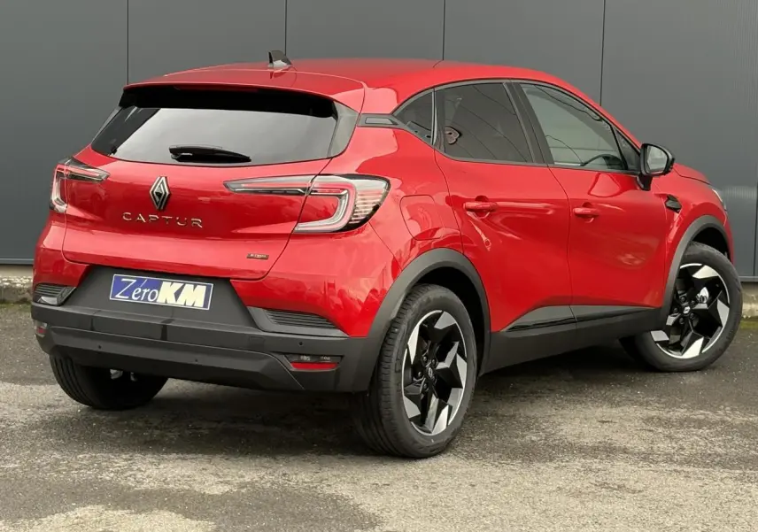 Vue 3/4 arrière droite du Renault Captur rouge flamme avec jantes aluminium 18 pouces et vitres surteintées.